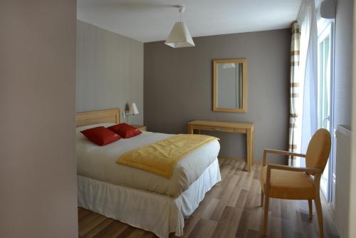 a bedroom with a bed and a table and a chair at Domitys Les Cépages in Gaillac