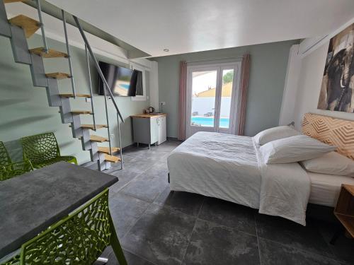 1 dormitorio con 1 cama y escalera de caracol en La Casa del Arti - Chambres d'hôtes en Sigean