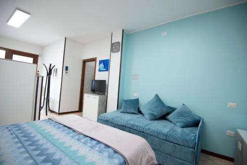 een slaapkamer met een bed en een bank bij Appartamento al Ponte di Luigi Viscovo in Pescantina