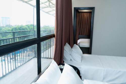 a hotel room with two beds and a balcony at Queen Central Hotel - Ben Thanh Market in Ho Chi Minh City
