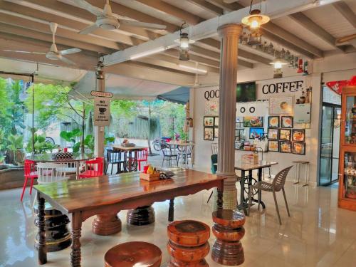 a restaurant with a wooden table and chairs at Qoo Hotel in Buriram