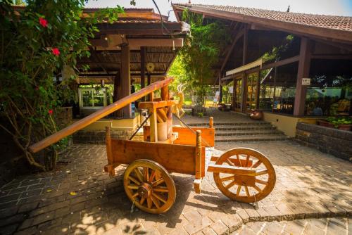 a wooden cart parked in front of a building at Malhar Machi Mountain Resorts in Mulshi