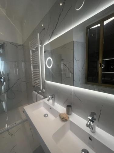 a white bathroom with a sink and a mirror at Hotel Gabriella in Rome