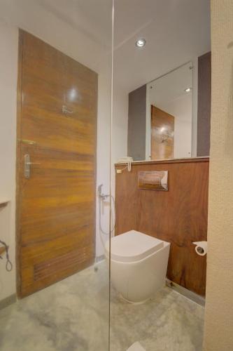 a bathroom with a toilet and a glass door at The Promenade in Puducherry