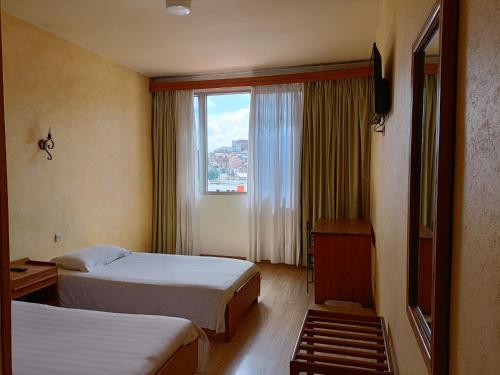 Habitación de hotel con 2 camas y ventana en Aina Hôtel, en Antananarivo