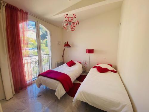 2 camas en una habitación con ventana en Appartement de la mer, en Sainte-Maxime