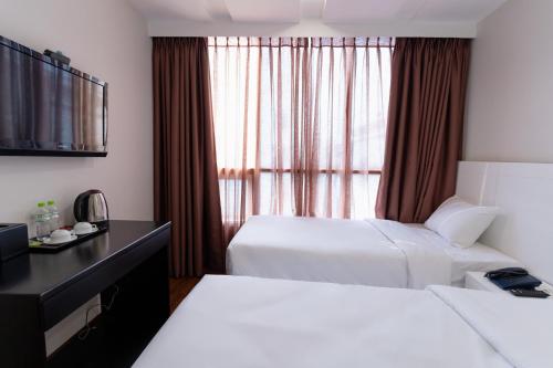 a hotel room with two beds and a window at Queen Central Hotel - Ben Thanh Market in Ho Chi Minh City