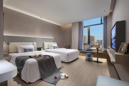 Habitación de hotel con 2 camas y TV de pantalla plana. en Spey Hotel en Guangzhou