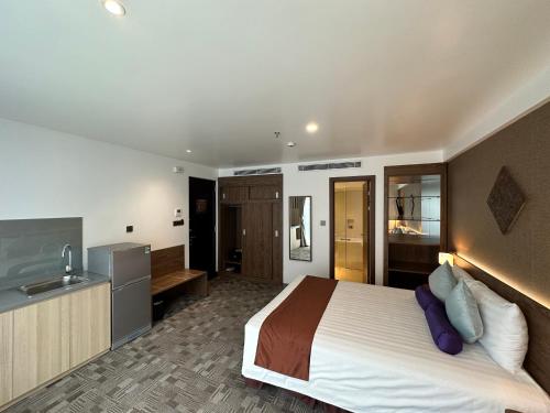 a hotel room with a bed and a kitchen at Hotel Yah Hanoi & Spa in Hanoi