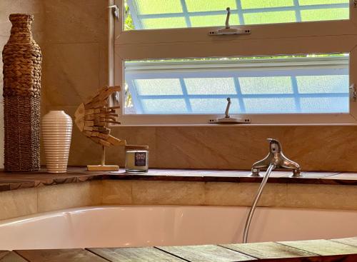 a bath tub in a bathroom with a window at Maison Taina in Arue