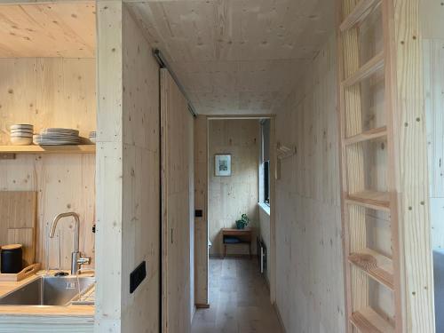 een kamer met houten wanden en een keuken met een wastafel bij Buitenplaats Vinckeboom in Diepenheim
