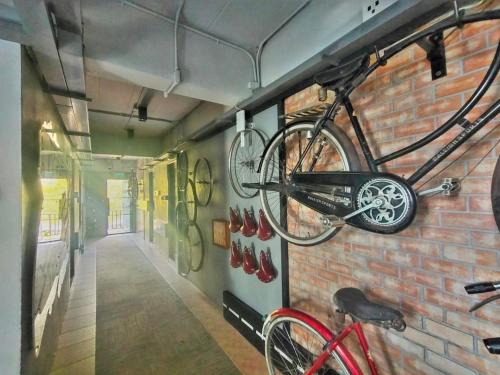 a bike is hanging on a brick wall at Qoo Hotel in Buriram