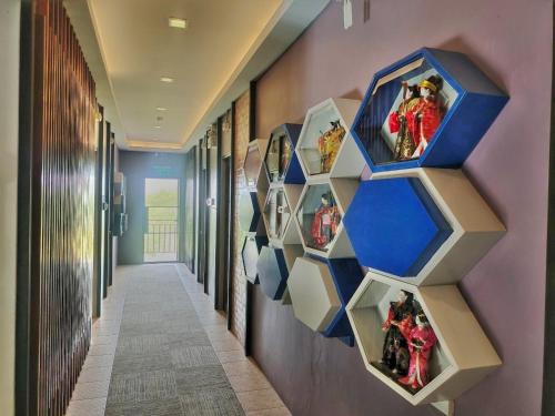 a hallway with a wall display of action figures at Qoo Hotel in Buriram