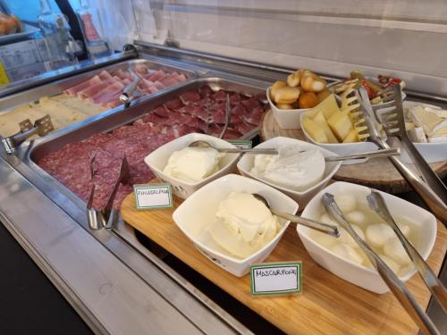 a display case with different types of meats and cheese at Hotel Orchidea in Lignano Sabbiadoro