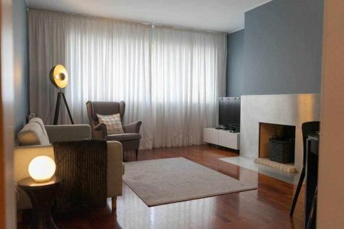a living room with a couch and a fireplace at MariGold by Destiny Houses in Senhora da Hora