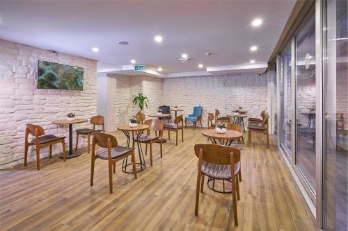 a restaurant with tables and chairs and a brick wall at ACTUEL LİFE HOTEL in Istanbul
