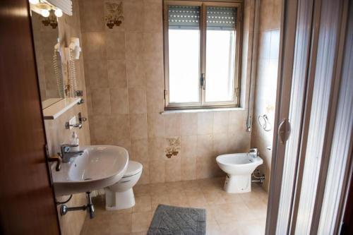 a bathroom with a sink and a toilet and a window at Bed and Breakfast Sapore di Sale in Trapani