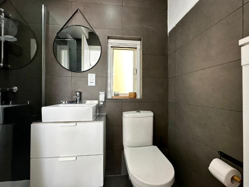 uma casa de banho com um WC, um lavatório e um espelho. em Cosy Penthouse in Hamrun - Walking distance to Valletta em Hamrun