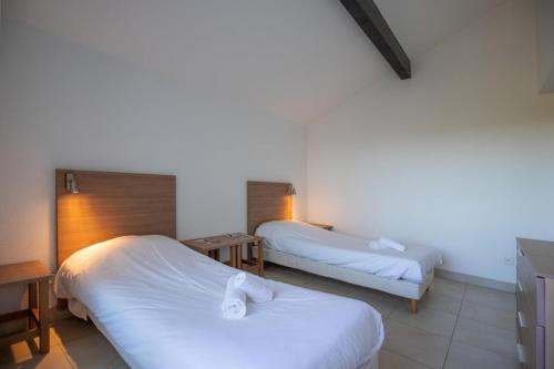 a hotel room with two beds with white sheets at VVF Résidence Anglet in Anglet