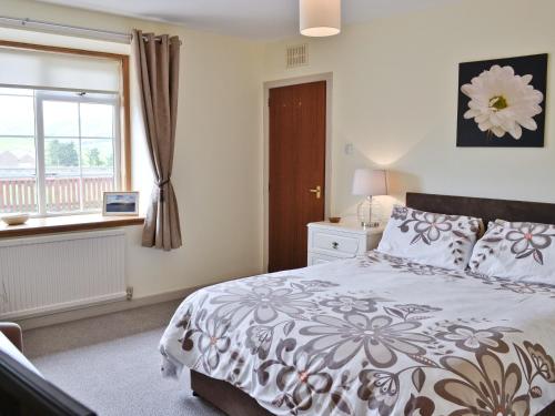 1 dormitorio con cama y ventana en Mill Shore Cottage - 26817, en Pennan