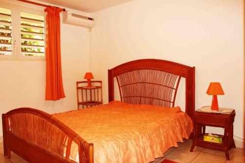ein Schlafzimmer mit einem Bett, einem Stuhl und einem Fenster in der Unterkunft Eden Part' - Appartement avec jardin privé à Baie-Mahault in Baie-Mahault