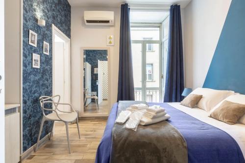 a hotel room with a bed and a chair at Scaramantico Rooms in Naples
