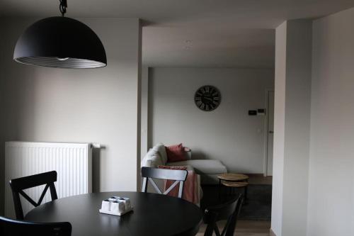 Momaison charmant landelijk appartement في Knesselare: غرفة معيشة مع طاولة وأريكة