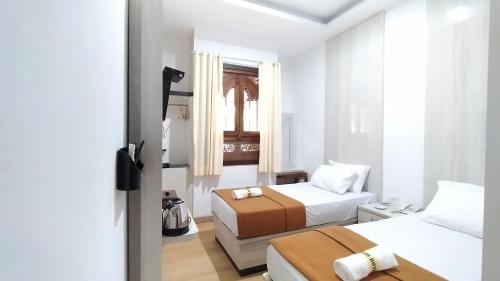 Banjar的住宿－HOTEL DHD，一间小卧室,配有两张床和窗户