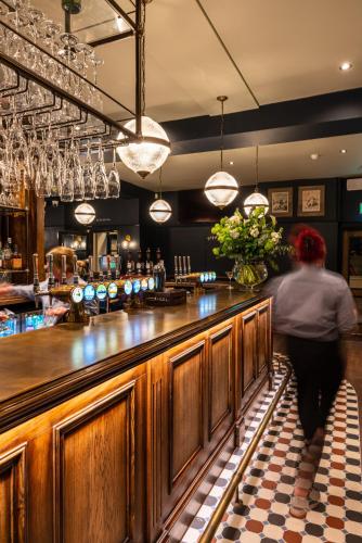a man standing at a bar in a pub at The Crown Inn in Bromley