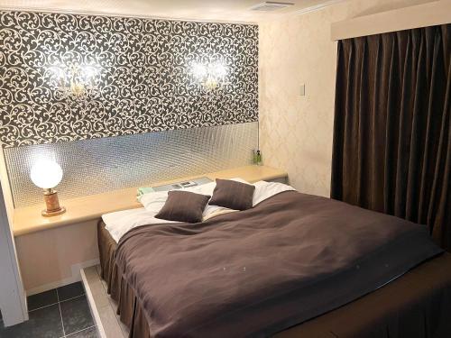 ein Schlafzimmer mit einem großen Bett und einer Wand mit einem Muster in der Unterkunft ホテル 夢街道 