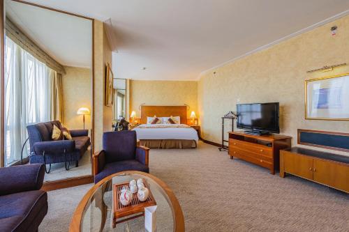 a hotel room with a bed and a television at Hotel Nikko Dalian in Dalian