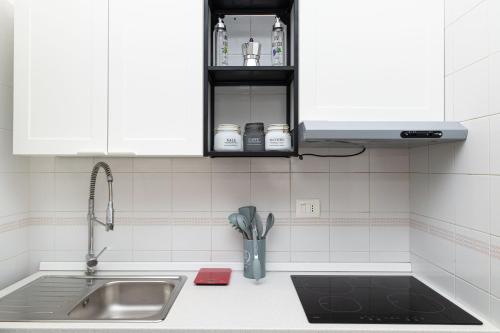 a kitchen counter with a sink and white cabinets at Casa Cocò - Rivabella Gallipoli in Rivabella