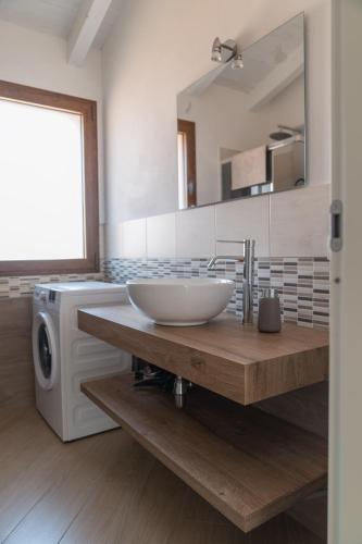 a bathroom with a sink and a washing machine at Waterfront apartment Olbia in Olbia