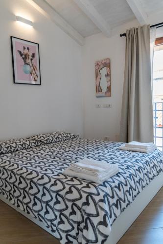 a bedroom with a bed with a black and white comforter at Waterfront apartment Olbia in Olbia