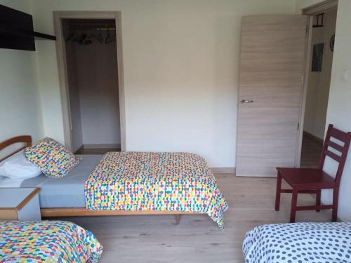 a bedroom with two beds and a chair at Casa María VUT 5614 AS in Villaviciosa