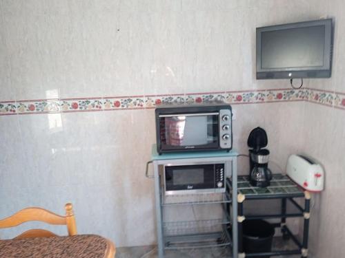 a small kitchen with a microwave and a tv at Casa María VUT 5614 AS in Villaviciosa