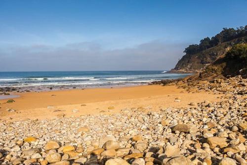a beach with a lot of rocks and the ocean at Casa María VUT 5614 AS in Villaviciosa