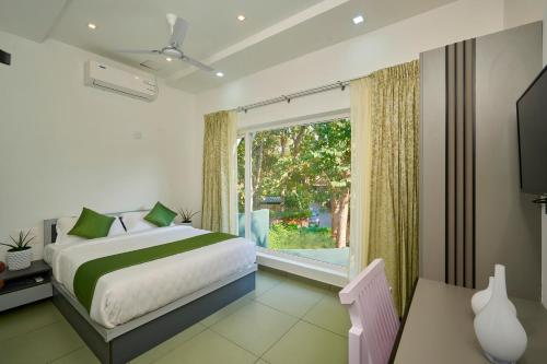 a bedroom with a bed and a large window at The Elms Thekkady in Thekkady