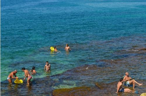 a group of people playing frisbee in the ocean at Le Stanze di Maria-Ingresso Autonomo Maria's Rooms-Indipendent Entrance in Giovinazzo