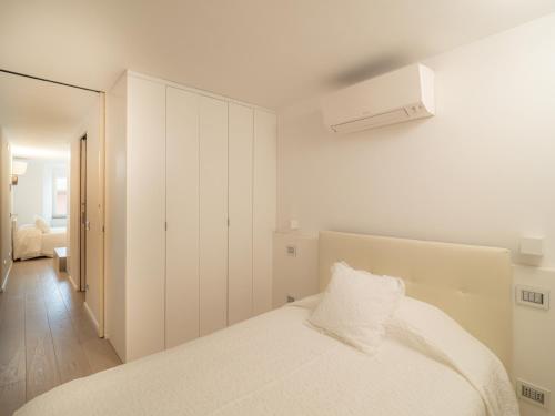 Dormitorio blanco con cama y armario en White dreams, en Portovenere