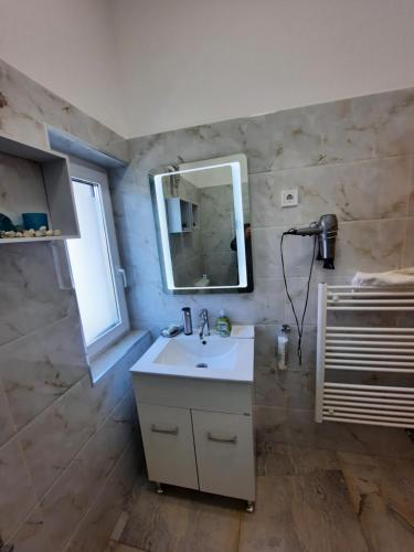 a bathroom with a sink and a mirror at Frangipani in Siófok