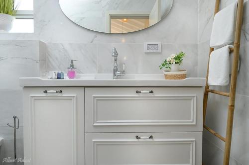 a bathroom with a white sink and a mirror at סוויטת בוסתן ונחל in Dafna