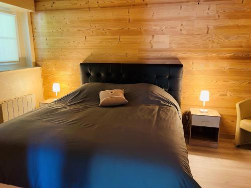 a bedroom with a large bed with wooden walls at ※ Résidence POMME DE PIN - Terrasse - Nature ※ in Xonrupt-Longemer