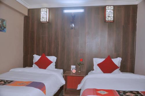two beds in a room with red and white pillows at Sapa Hills Hotel in Sa Pa