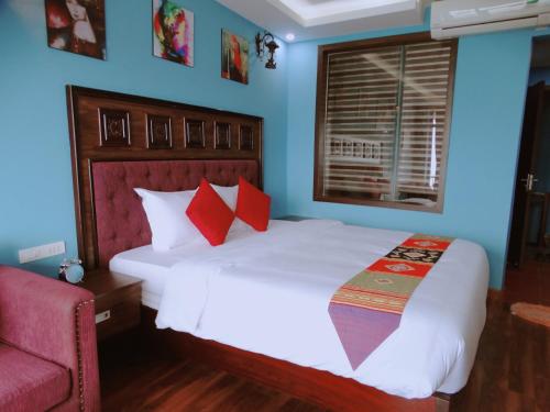 a bedroom with a large white bed with red pillows at Sapa Hills Hotel in Sa Pa