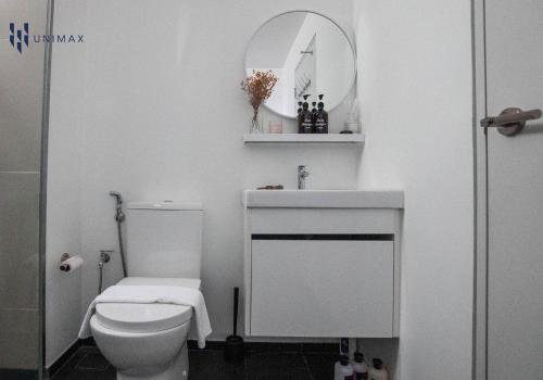 a white bathroom with a toilet and a sink at UNA Sunway Velocity Kuala Lumpur by Unimax in Kuala Lumpur