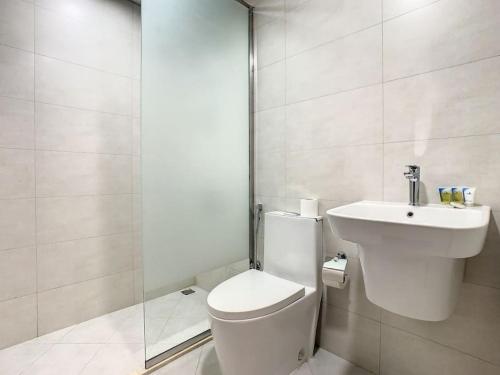 a white bathroom with a toilet and a sink at Key View Hera Tower in Dubai