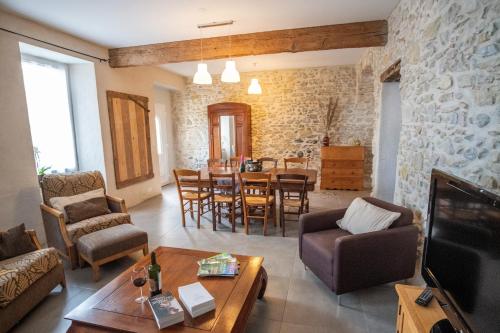uma sala de estar com um sofá e uma sala de jantar em Charme au cœur des vignes em Malras