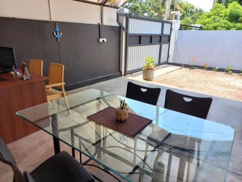 a glass table and chairs on a patio at The Anchorage Holiday Apartments - Negombo in Negombo