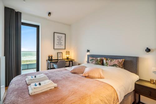 een slaapkamer met een groot bed en uitzicht op de oceaan bij -The One- verbazingwekkend nieuwbouwapp zeezicht in Blankenberge